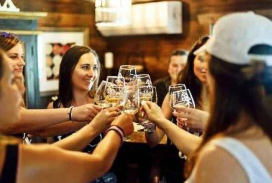 A group of girlfriends in a restaurant each holding up a glass of wine to toast