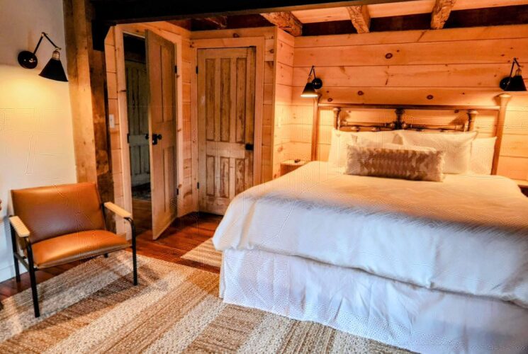 Cozy bedroom with king bed, wood shiplap feature wall and leather sitting chair